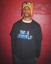 Load image into Gallery viewer, Skateboarder Chucky Lane wearing the Stingwater &quot;Do a Candyflip&quot; T-shirt in black with bold blue font and white icy snow capped letters with a red brick backdrop in NYC
